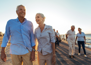 old people walking on beach